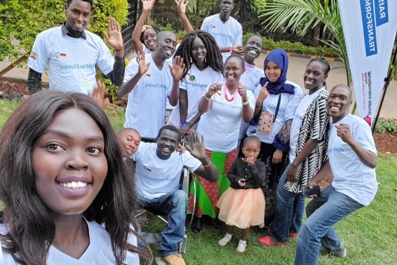 A group of people face the camera and smile.