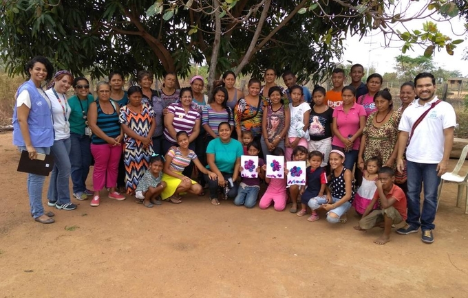 Group of people posing for a picture under a tree.