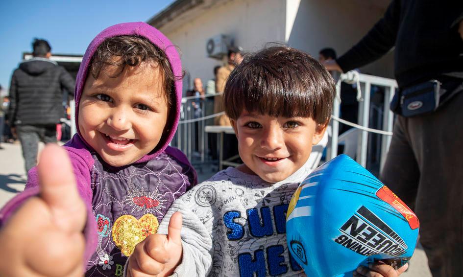 Two children in a refugee camp smiling