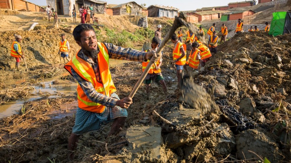 Rohingya refugees clear a drainage channel at Kutupalong settlement in Bangladesh, as part of a joint UNHCR, IOM and WFP project to mitigate monsoon flooding.