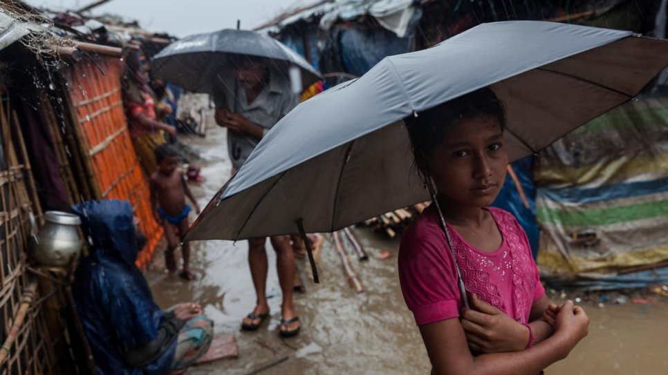 A young Rohingya girl stands in the rain at a refugee settlement in Shamlapur, southeast Bangladesh.