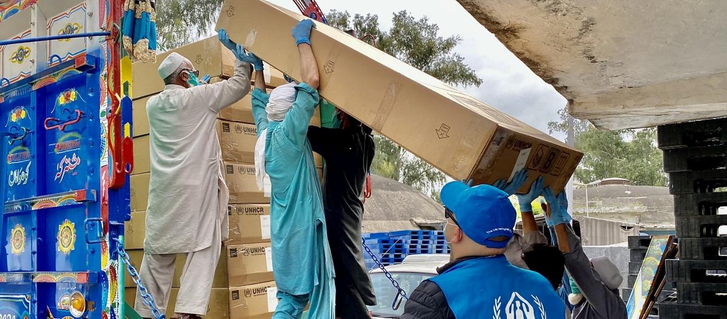 A l'entrepôt central du HCR à Nowshera, Pakistan, des travailleurs chargent des fournitures essentielles en vue d'une expédition par camion dans le cadre de la réponse au coronavirus. 