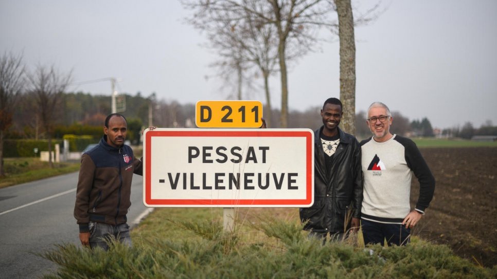Gerard Dubois (right), the mayor of the French town of Pessat-Villeneuve, poses with resettled refugees Ibrahim and Alfatih.