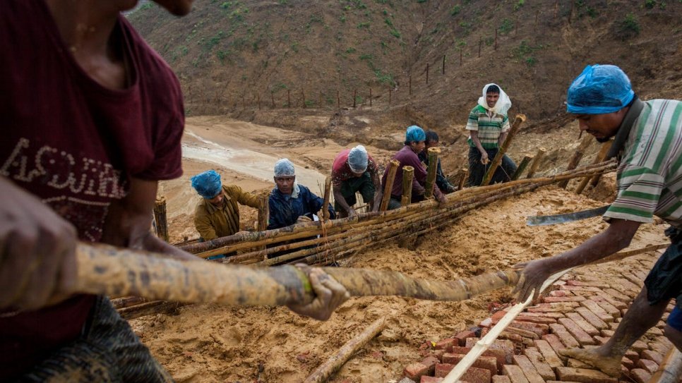 Supervised by UNHCR, Rohingya workers build an all-weather footpath as heavy rains threaten Kutupalong refugee settlement, Bangladesh.