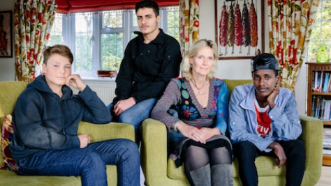 United Kingdom. Ingrid Van Loo Plowman and her youngest son Ross, host three refugees in their home in Epsom, near London: Isak, 18, from Ethiopia, 19-year-old Abdul, from Syria and a 31-year-old engineer from the Middle East who declined to be identified for security reasons. This portrait is part