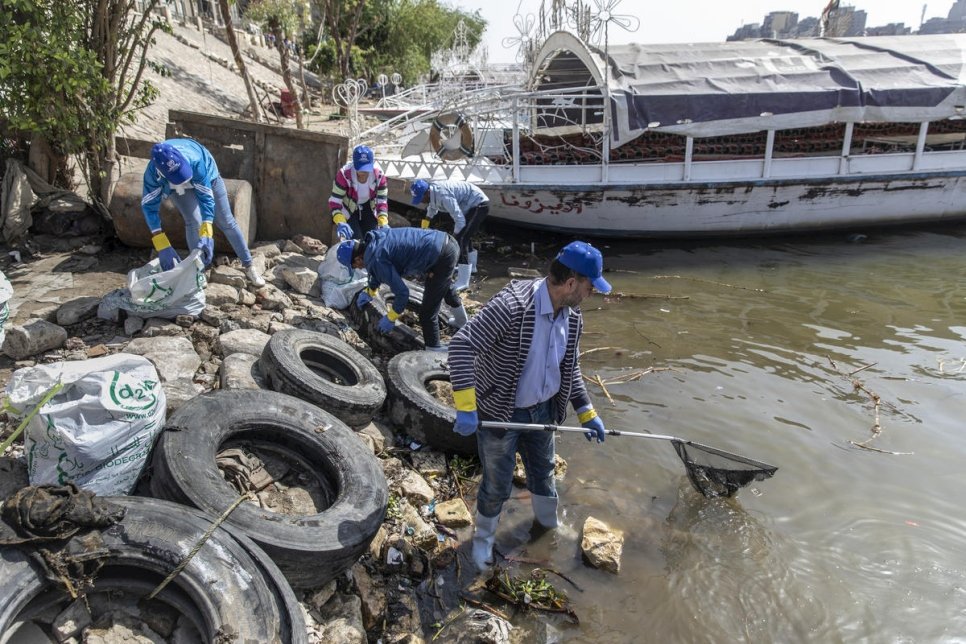 متطوعون من اللاجئين ينضمون إلى السكان المحليين للمساعدة في جهود التنظيف في نهر النيل في القاهرة.
