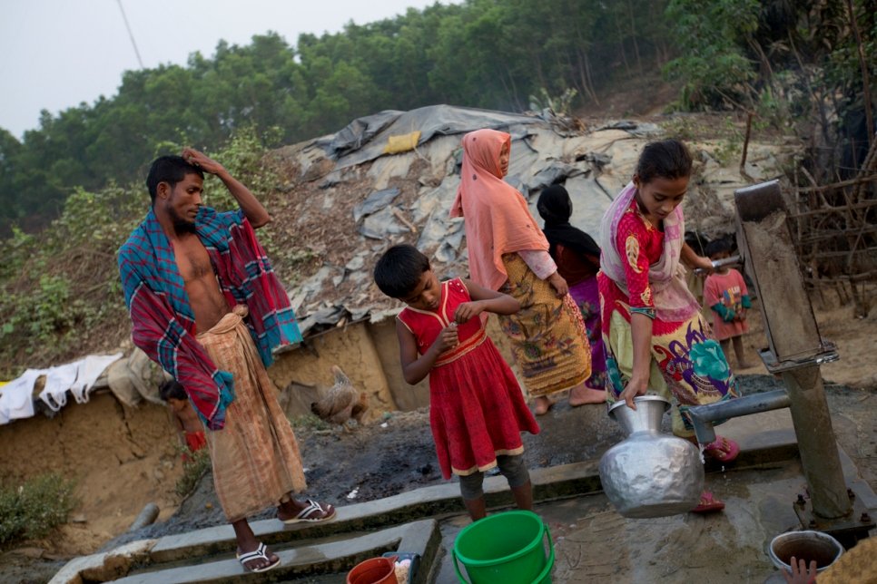 أسرة من الروهينغا وصلت حديثاً تملأ أدليةً بالماء من بئر في موقع مؤقت في كوكس بازار، بنغلاديش، حيث يعيش عشرات الآلاف من اللاجئين منذ اندلاع أعمال العنف في وقت سابق في ميانمار في أكتوبر 2016.
