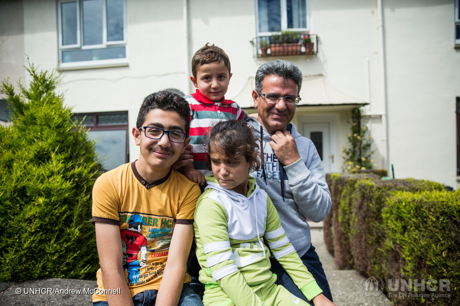 Mohammad, left, pictured with his sister Aisha, younger brother Oweis, and father Mohammed at their new home in Edinburgh, Scotland