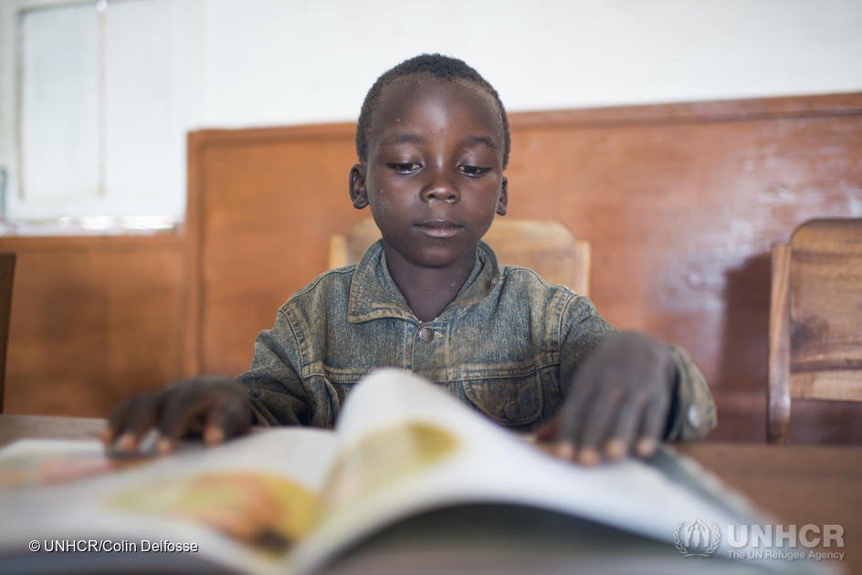 Jacques, un réfugié burundais de huit ans, lit un livre au camp de réfugiés de Lusenda, dans la province du Sud-Kivu, République démocratique du Congo. 