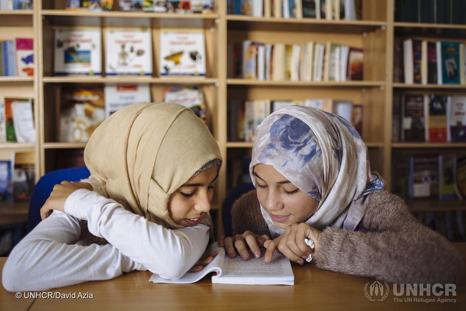 Ariam, à gauche, et Amneh, à droite, toutes deux réfugiées syriennes, lisent un livre ensemble à la bibliothèque du camp de réfugiés de Zaatari, en Jordanie. 
