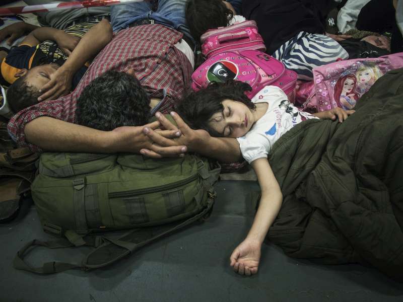 An exhausted Syrian family sleeps on an Italian Navy coastguard ship after being rescued from a fishing boat trying to cross the Mediterranean. 