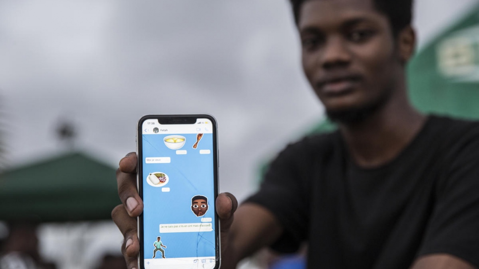 Ivorian graphic designer O'Plérou displays some of the emojis he has designed. 