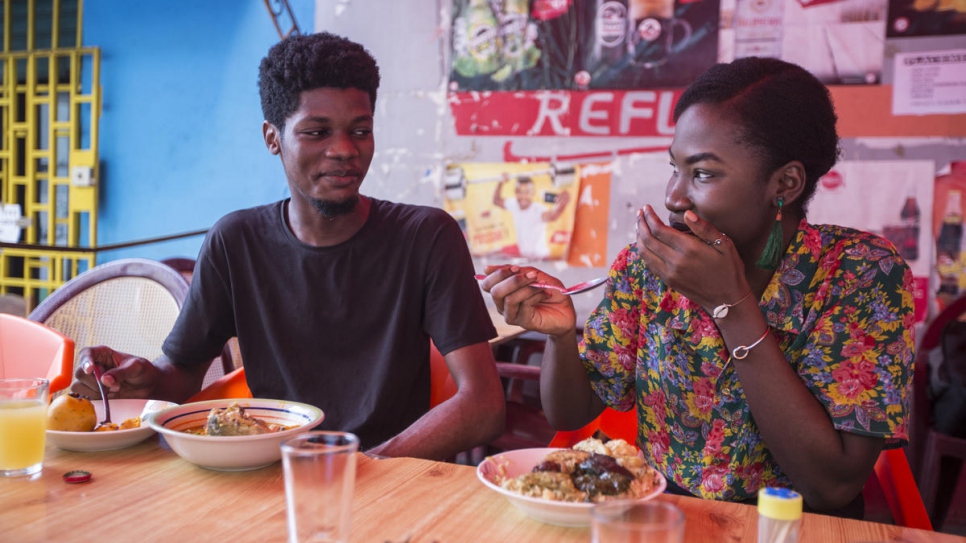 Ivorian graphic designer O'Plérou enjoys a traditional meal with a friend at a popular food joint in Abidjan, Côte d'Ivoire.