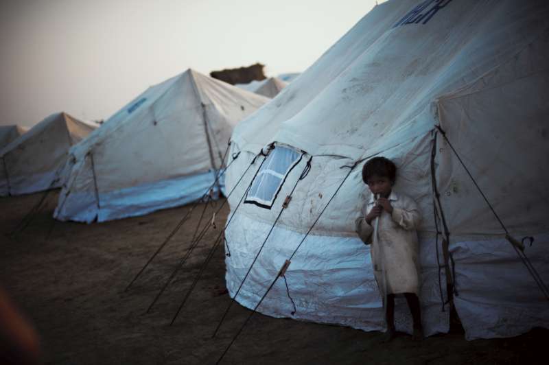 صبي يقف بجوار خيمة تابعة للمفوضية في مخيم الإغاثة الذي أنشئ لضحايا الفيضانات في إقليم السند، بباكستان.