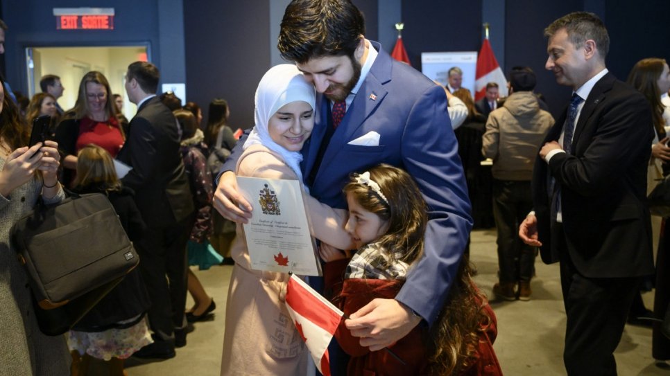 Tareq Hadhad (au centre), un réfugié syrien et le fondateur de Peace by Chocolate, serre sa famille dans ses bras après avoir reçu sa citoyenneté canadienne. 