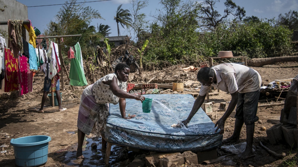 Après le passage du cyclone Idai à Buzi, Mozambique, un homme et une femme essaient de récupérer leur matelas qu'ils lavent avant de le sécher au soleil. 