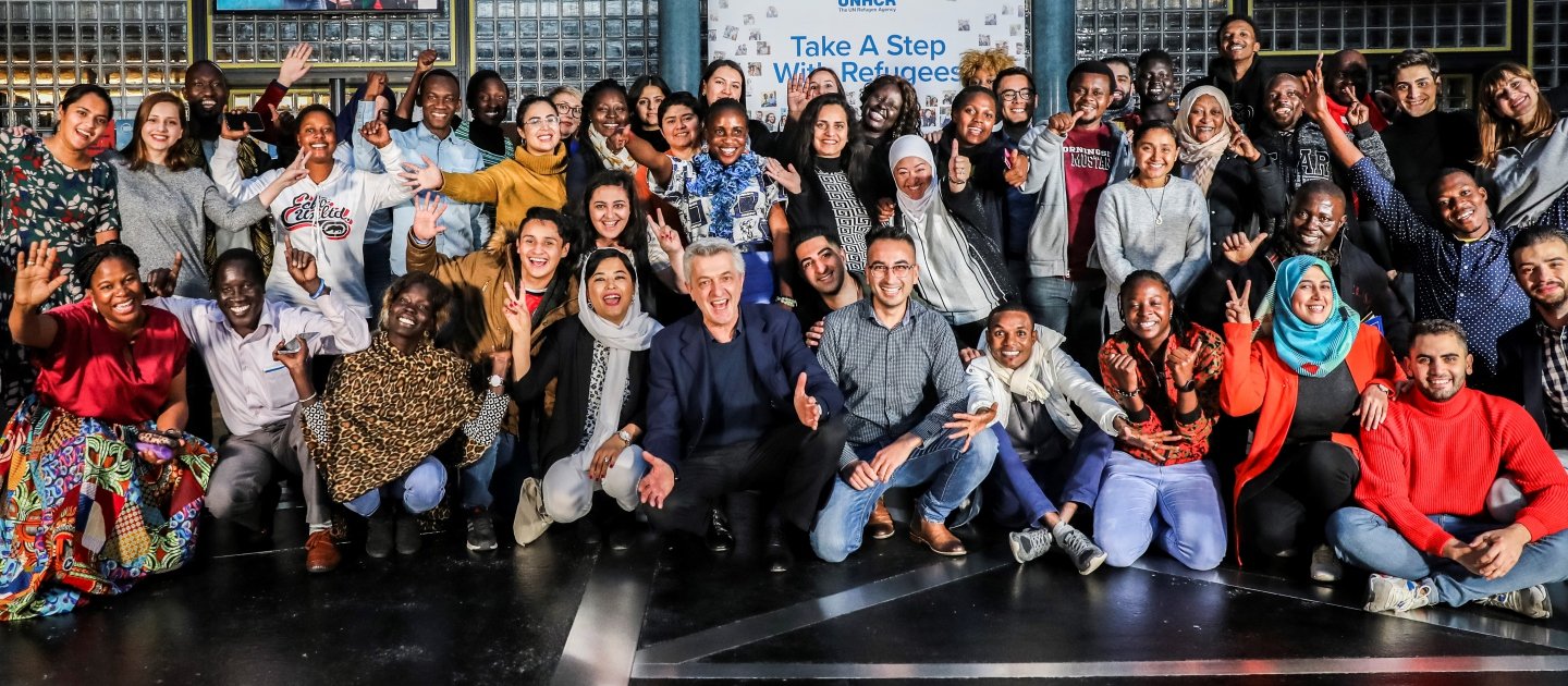 UN High Commissioner for Refugees Filippo Grandi (front-centre, crouching) meets a group of 70 young refugees attending the Global Refugee Forum in Geneva.
