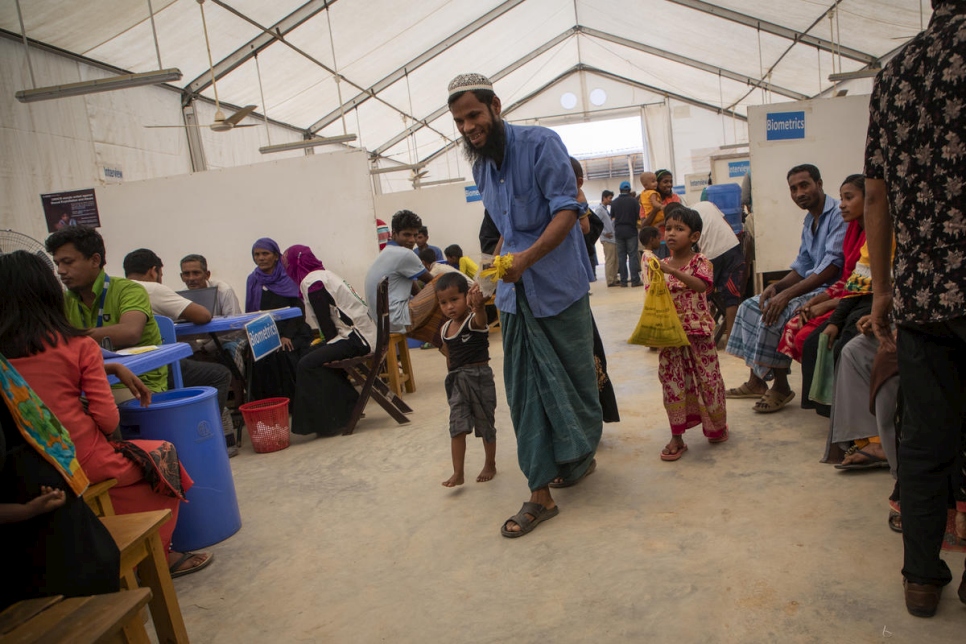 أسرة لاجئة من الروهينغا تزور موقعاً للتسجيل تابع للمفوضية في مخيم كوتوبالونغ للاجئين، بنغلاديش. 