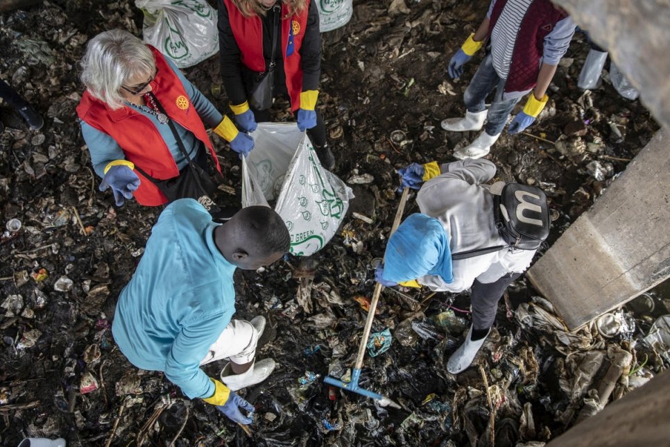 Omar (à gauche) et Mawadda (à droite), réfugiés soudanais, remplissent des sacs de déchets. 