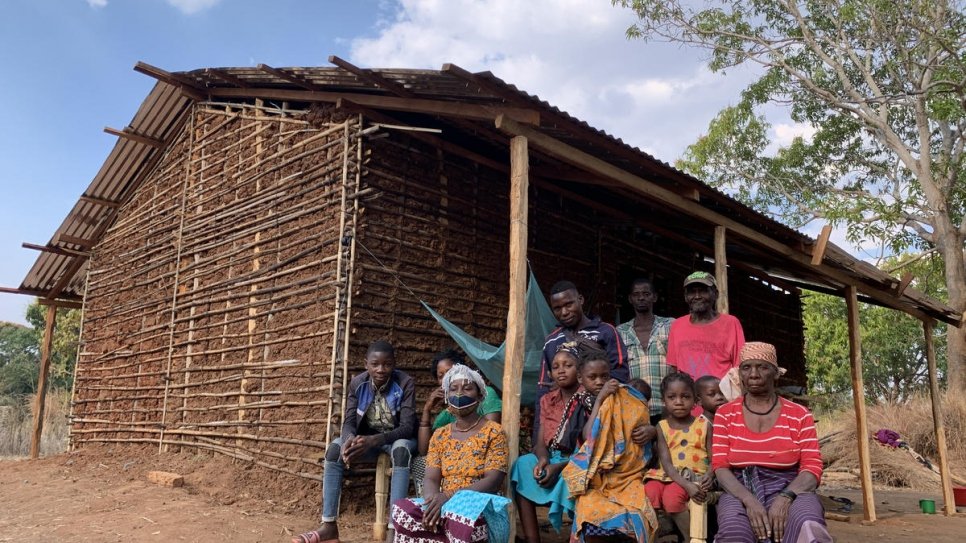 Joaquina* (équipée d'un masque) est assise avec sa famille et ses proches devant la maison de son frère à Montepuez, après avoir fui de violentes attaques au nord du Mozambique. 