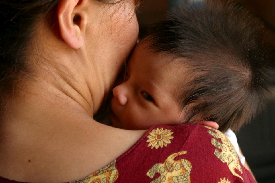 Turkmenistan. A woman holds her infant