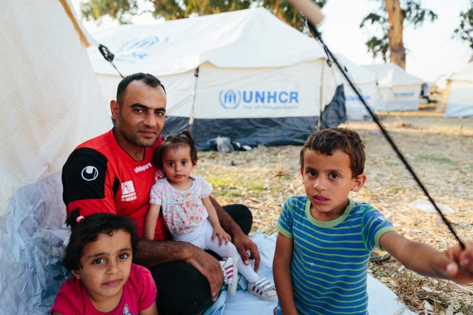 Mohammed Sadik Jalani, réfugié syrien, et ses enfants sont assis à côté de tentes installées par les autorités grecques et le HCR pour fournir un abri après que des incendies aient détruit le centre de réception et d'identification de Moria sur l'île de Lesbos, en Grèce. 