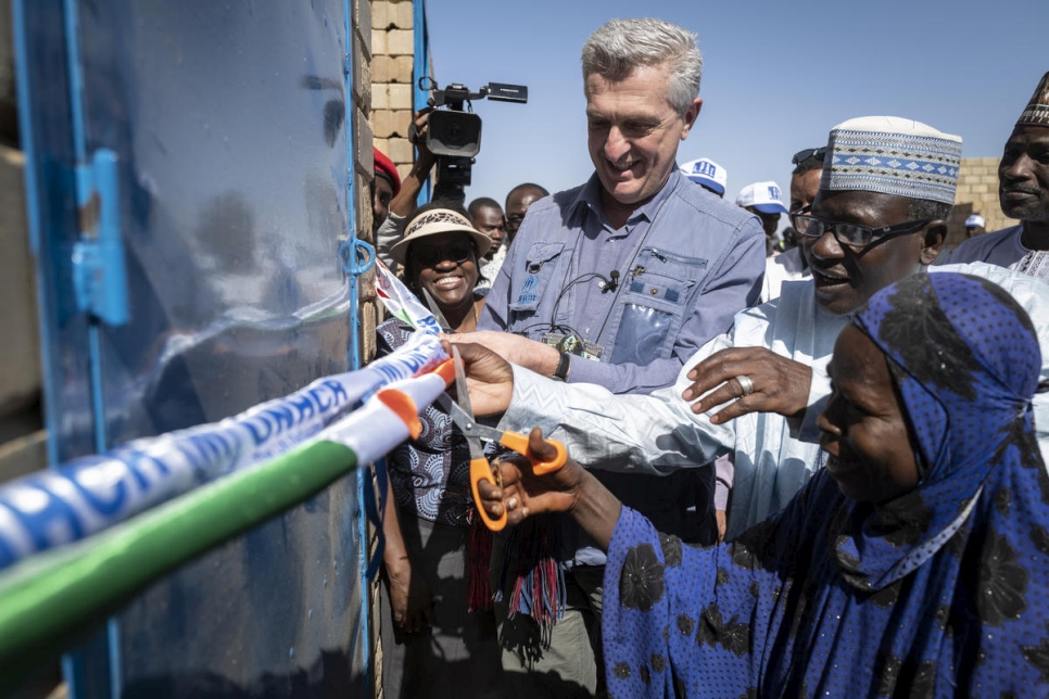 El Alto Comisionado de las Naciones Unidas para los Refugiados, Filippo Grandi, corta la cinta junto a Aminatou Chekaraou, el primer miembro de la comunidad de acogida en recibir una casa de ladrillos en Ouallam. 