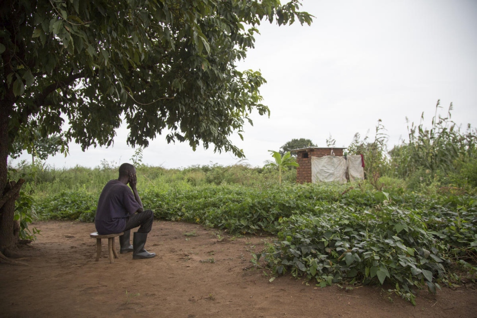 El refugiado sursudanés y padre de cinco Adam* se sienta fuera de su albergue en el asentamiento Bidibidi de Uganda. Su esposa Mary* fue diagnosticada con trastorno bipolar en 2012 y luego se quitó la vida en el exilio. 