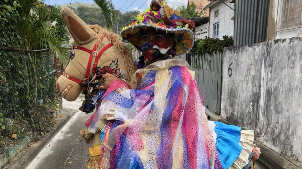 María posa con su Burriquita, mientras la agrupación de que hace parte, Moko Somõkõw, se prepara a salir para el desfile.