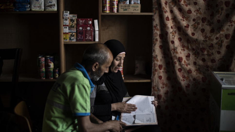 Kawkab y su esposo Rabie revisan los libros de contabilidad de su tienda de conveniencia.