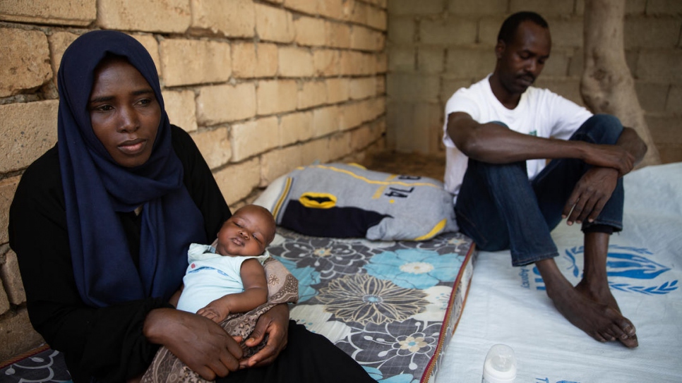 Newborn Afnan dozes in her mother Halima's arms outside their home in Tripoli, Libya.