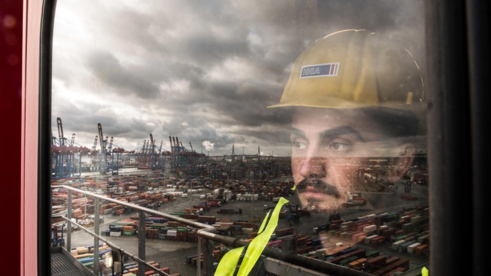 El refugiado sirio Majed Al Wawi, de 21 años, trabaja en una grúa de contenedores en la terminal de contenedores Burchardkai, la instalación más grande y antigua para el manejo de contenedores en el puerto de Hamburgo. 