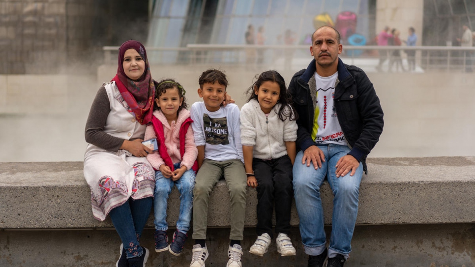 Wafaa, Meshael, Adnaan, Sidra and Minwar sit outside the Guggenheim Museum in Bilbao, on a day trip with community volunteers.