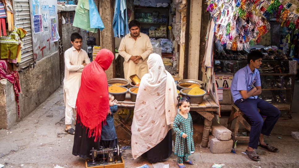 Mohammad, who opened a bank account last year, serves customers at his shop.