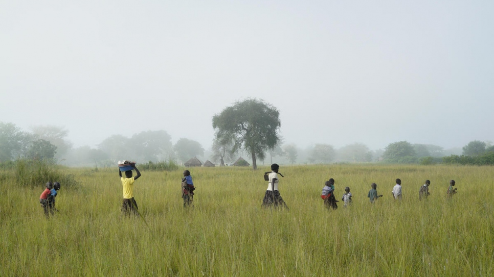 Queen's children help out on her land at Oligi settlement, where she grows rice.