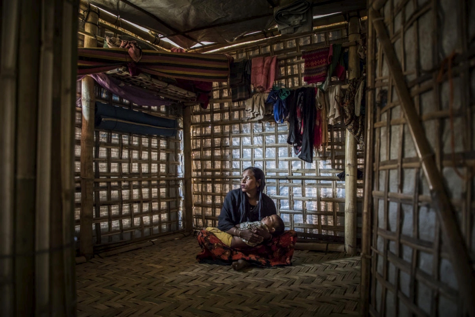 Rahima Khatun sostiene a su hijo Mohammad Arafat mientras duerme en su hogar en el Campamento 1 Oeste, Kutupalong, Cox's Bazar, Bangladesh. 