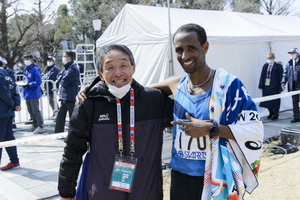 Después de la carrera, Yonas celebra con su entrenador en Japón, Naruyosi Karasawa. 