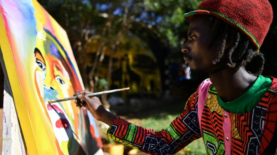 Mike, who fled Burundi in 2015, works on a painting at the art centre.