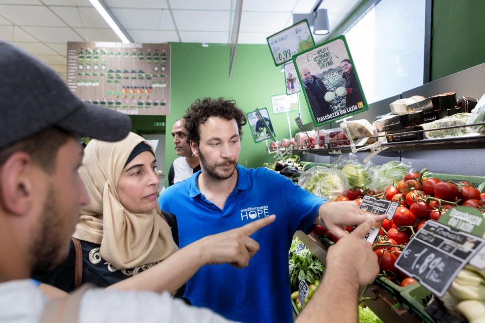 Stefano Specchia de la Federación de Iglesias Evangélicas muestra a Hanadi, de 39 años y un refugiado palestino de Siria, cómo los supermercados italianos etiquetan las verduras. 