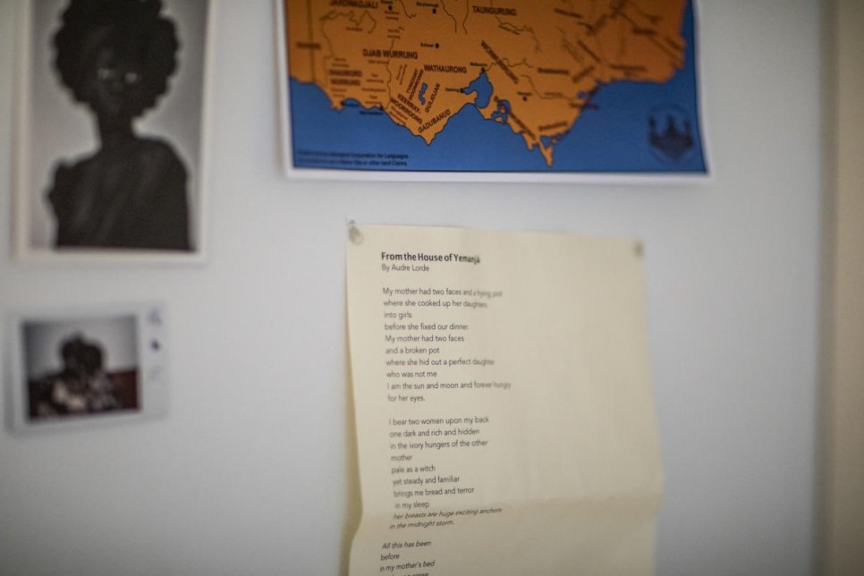 Postcards, poetry and a polaroid decorate wall where Bigoa Chuoi works. The poet's family fled Sudan's conflict and she was resettled as a refugee in Australia. 