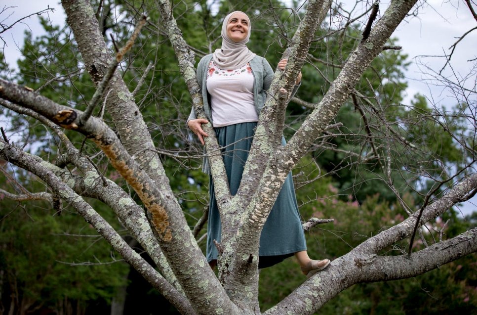 رنا الدجاني تتسلق شجرة بالقرب من منزلها في ريتشموند، فيرجينيا، حيث كانت تقيم هناك خلال فترة إغلاق مطار الأردن بسبب فيروس كورونا.