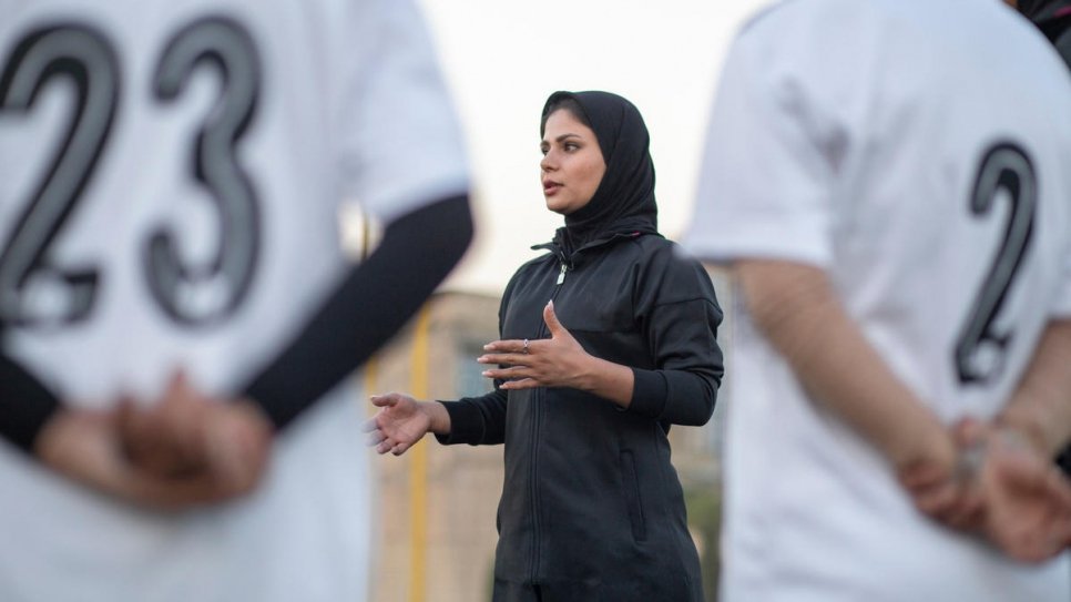 Rozma leads a football coaching session for girls.