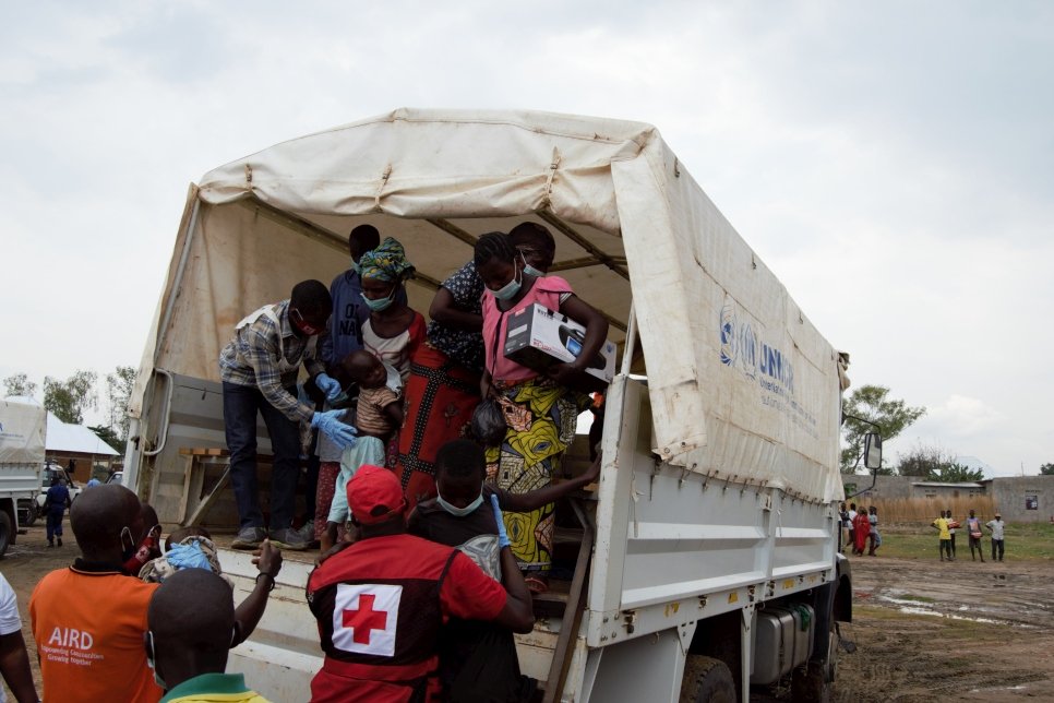 Des rapatriés burundais depuis la RDC descendent d'un camion au centre de transit de Gatumba, au Burundi. 