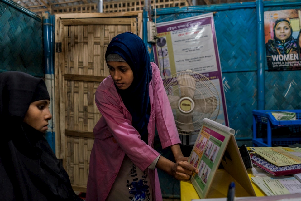 La partera Shirin Akter, de 21 años, enseña a Romida Begue, de 25 años, madre de dos hijos rohingya embarazada, sobre su salud durante el embarazo en un centro de atención primaria financiado por ACNUR y UNFPA en Bangladesh.  