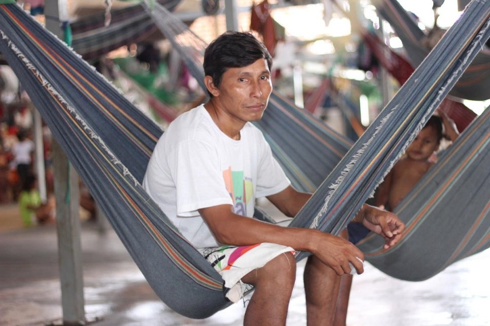 قائد مجتمع واراو، إليجيو تيجيرينا، 33 عاماً، يجلس على أرجوحة بالقرب من أطفاله في مأوى بينتولانديا في بوافيستا، شمال البرازيل.