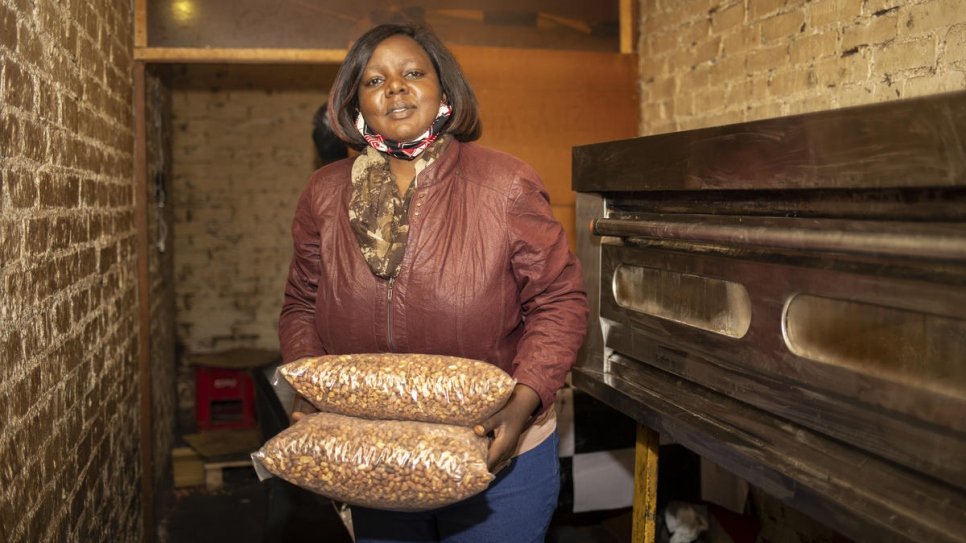 Grace, une réfugiée congolaise de 43 ans, transporte des sacs d'arachides grillées dans son entreprise à Pretoria, en Afrique du Sud. 