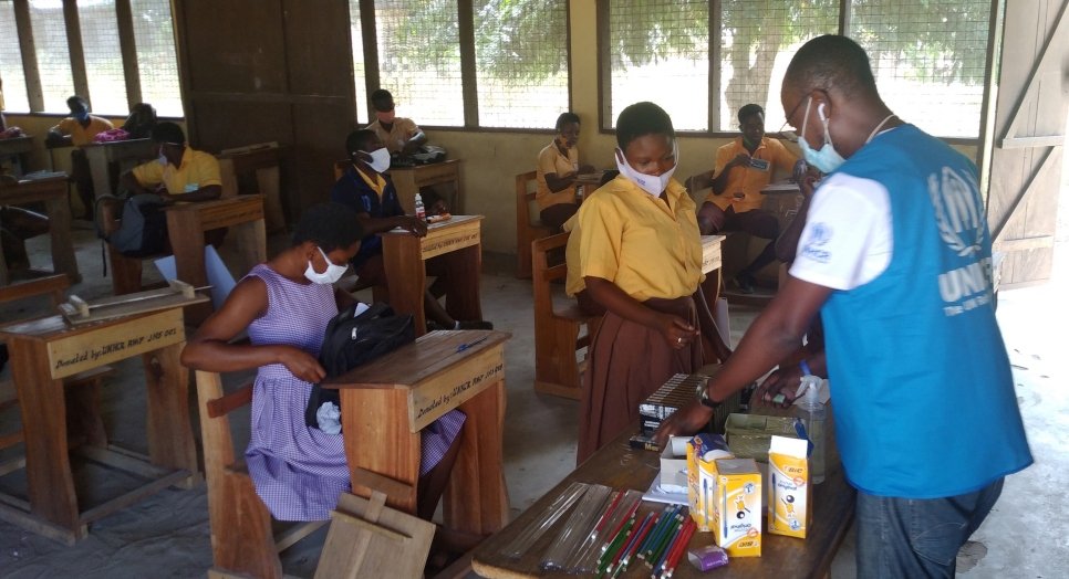 Des étudiants de dernière année observent la distanciation sociale alors qu'ils reçoivent des fournitures scolaires avant leurs examens finaux à l'école communautaire d'Ampain au Ghana. 