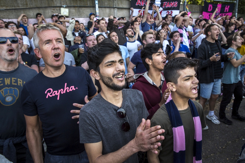 Al-Shaabin brothers, Mohammed, Islam, and Zain watch their local football team Dulwich Hamlet FC. They came to the UK as part of the community sponsorship programme, and UNHCR met them and their sponsors in their new home in Peckham, South London. 