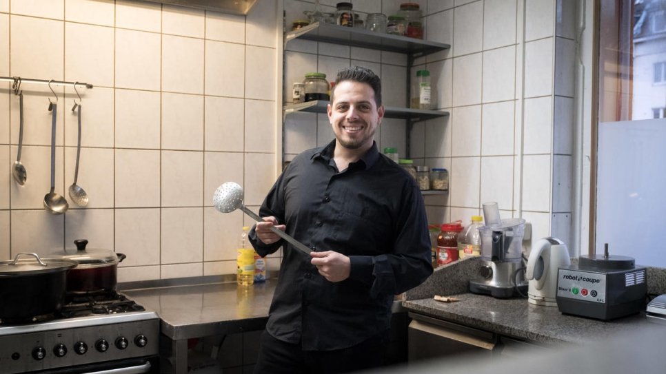 Fadi Zaïm, un réfugié syrien de 32 ans, dans la cuisine de sa mère Salma Al Armarchi à 	Berlin d'où elle exploite son entreprise, Jasmin Catering. 