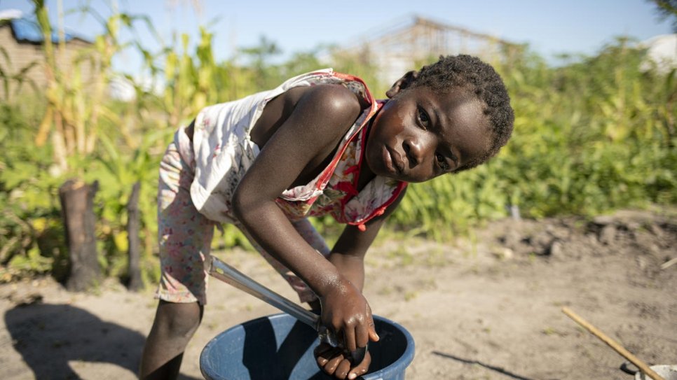 Amelia's daughter Rosa, 8, washes clothes in Savane settlement. The family was relocated there by the government after Cyclone Idai hit a year ago.